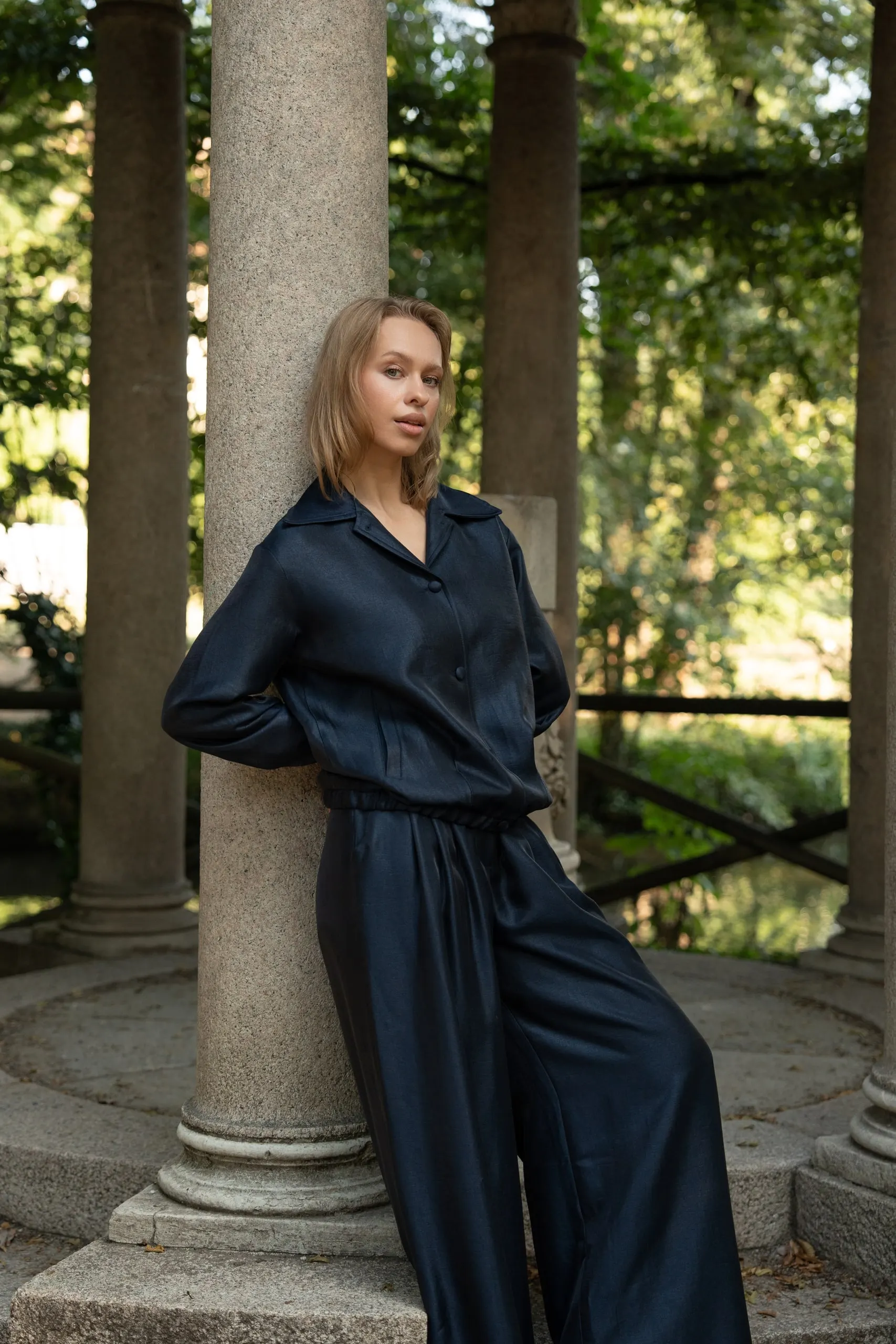 Clothé — navy satin, against the column