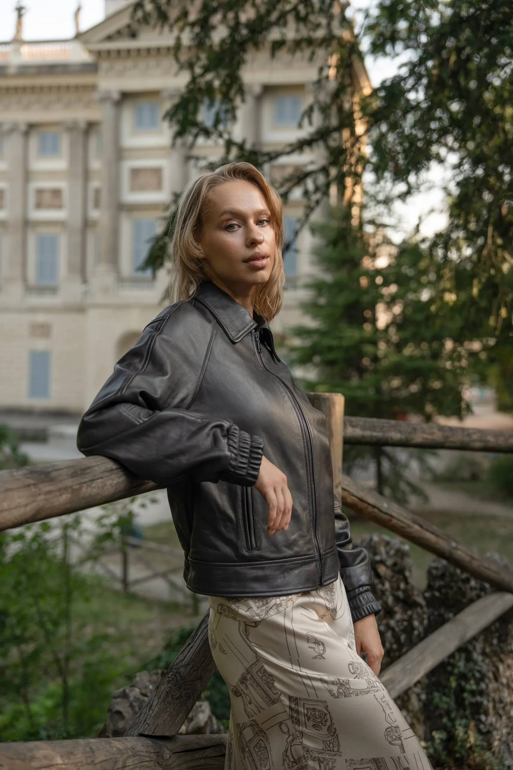 Clothé — leather jacket over cream skirt