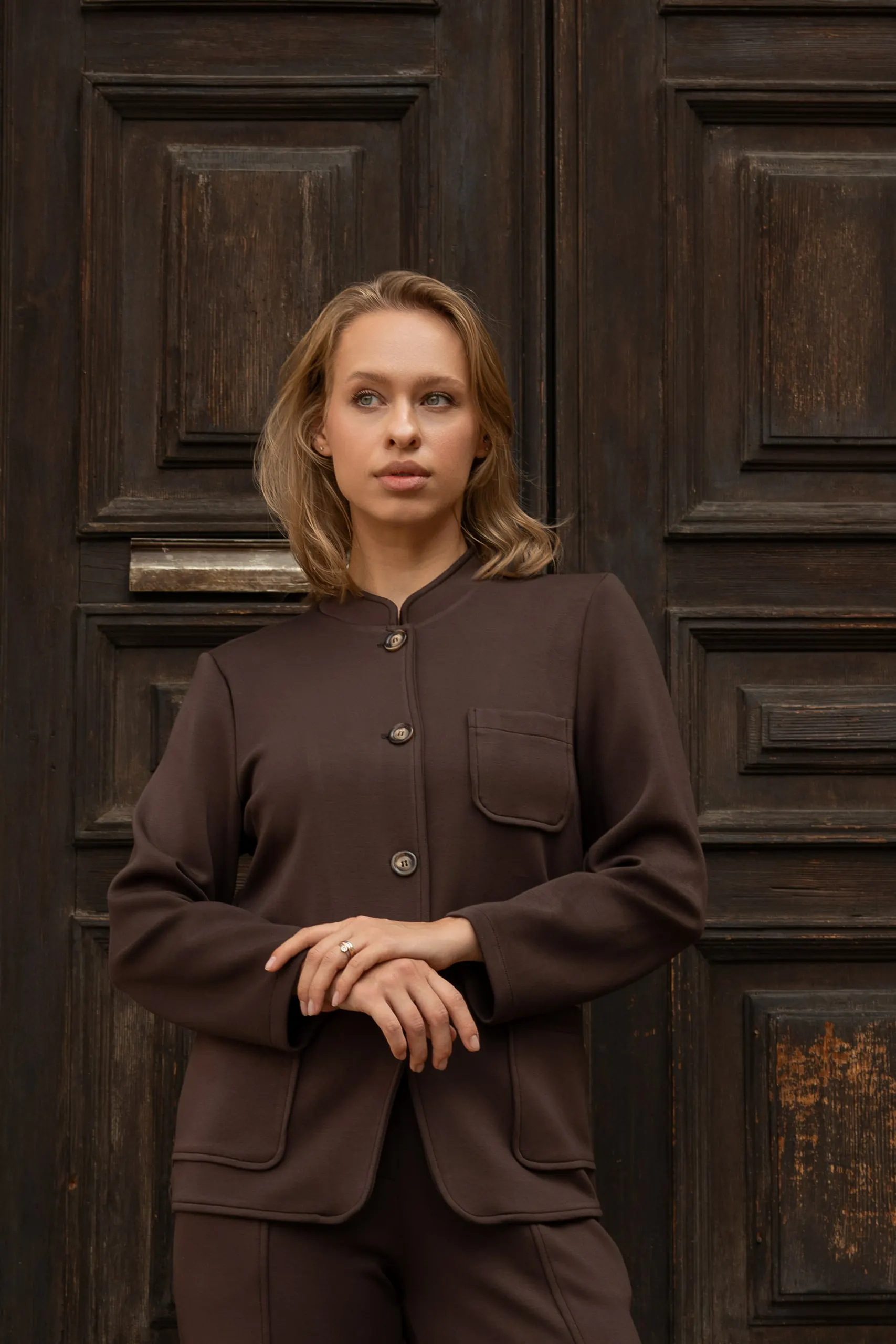 Clothé — brown suit at the historic door