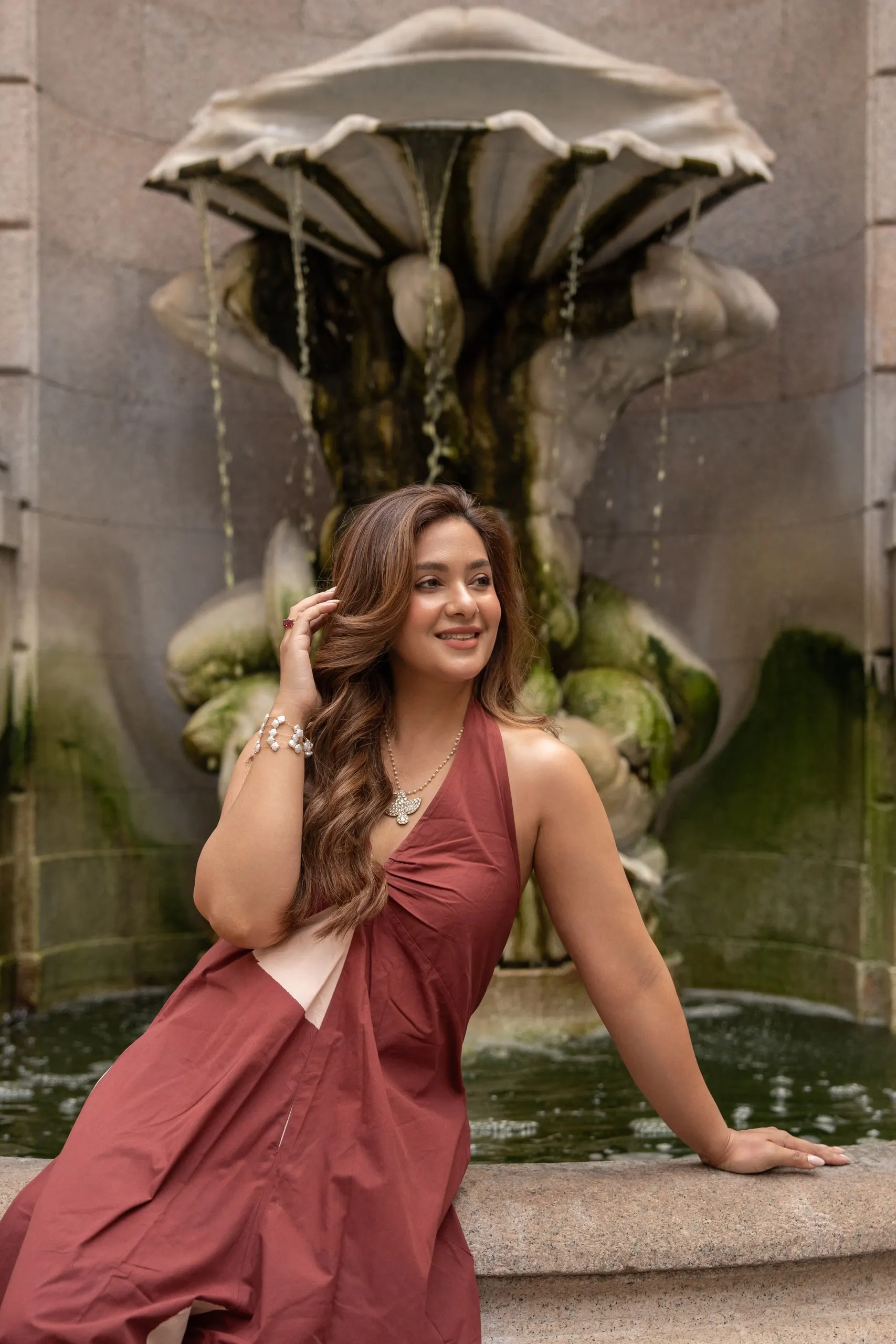 Megha Sehra — a shoot in Milan — by the fountain in a terracotta dress